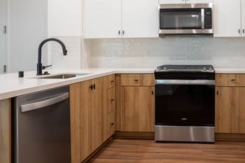 A modern kitchen with wooden cabinets and stainless steel appliances.
